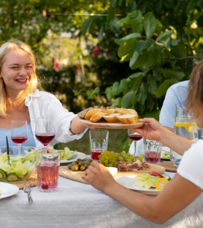 Finom ételekkel kínálják egymást a kerti parti vendégei.